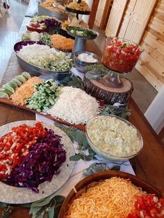 many different types of food are on the buffet table, including salads and dips