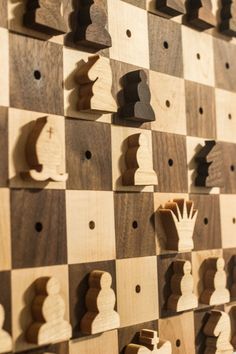 wooden chess pieces are arranged on a wall