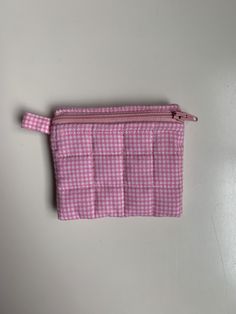 A pink coin purse with a gingham print on the outside and inside with a small pink handle on the outside that can be used for a keychain. it also includes some white bias tape on the inside. This coin purse can fit some cards, cash, or any similar small items. Cute Pink Coin Purse With Card Slots, Cute Pink Coin Purse With Zipper Closure, Pink Pouch Coin Purse With Card Slots, Cute Pink Coin Purse With Zipper, Cute Pink Pouch Coin Purse, Pink Rectangular Coin Purse With Card Slots, Pink Zipper Pouch Coin Purse, Pink Coin Purse With Card Slots For Personal Use, Pink Pouch Wallets For Personal Use