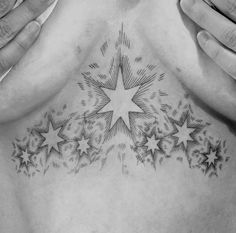 a man's chest with stars on it and his hands covering the chest area