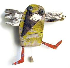 a bird made out of wood and painted red, white and yellow with two eyes on it's body