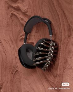 a pair of black headphones sitting on top of a wooden surface with metal spikes