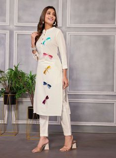 Elevate your ethnic wardrobe with this stunning embroidered kurta suit set crafted from pure linen. The kurta pant set includes a straight kurta with a mandarin neck, 3/4 sleeves, front button placket, and beautiful butterfly thread embroidery. The pant features a partially elasticated waist for added comfort and style. Perfect for any festive occasion or special event, this ensemble is sure to make you stand out in the crowd. Spring Cotton Traditional Wear With Mirror Work, Spring Traditional Cotton Wear With Mirror Work, White Linen Eid Sets, Spring Traditional Wear With Mirror Work, White Linen Sets For Eid, Linen Straight Kurta With Resham Embroidery, Linen Kurta With Resham Embroidery, Straight Linen Kurta With Resham Embroidery, Fitted Linen Straight Kurta Set