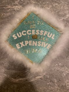 a blue and white graduation cap that says i have to be successful, i like expensive things