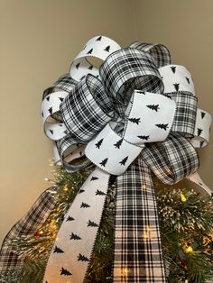 a christmas tree decorated with black and white plaid ribbon, bats and stars on it