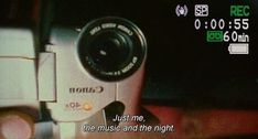 a person holding a camera in their hand with the caption just me, the music and the night