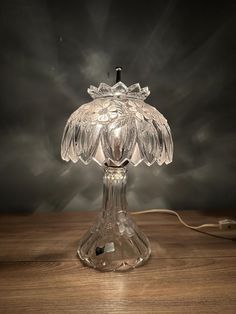 a glass table lamp on a wooden table