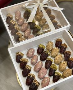 two boxes filled with assorted chocolates on top of a table