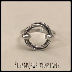 This ring is made with a sterling silver open circle that has a really neat design that twists as it goes around. Sterling silver wire has been added to make up the band of the ring. This ring is super comfortable to wear. Use the options pull down menu to select your ring size. Comes wrapped and ready to gift if needed. To see my other rings, click here: https://www.etsy.com/shop/SusansJewelryDesigns?ref=seller-platform-mcnav&section_id=7658693 Modern Twist Bypass Ring As Gift, Silver Midi Rings With A Modern Twist For Gifts, Elegant Sterling Silver Midi Rings, Elegant Silver Circle Midi Rings, Adjustable Stackable Rings With A Modern Twist, Adjustable Round Jewelry With A Modern Twist, Adjustable Open Circle Promise Ring, Adjustable Round Jewelry With Modern Twist, Wire Wrapped Round Ring For Promise