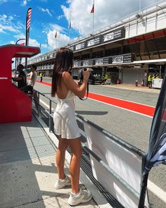 a woman taking a photo on the side of a race track