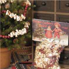 a bag of popcorn sitting next to a christmas tree with a card in it on top