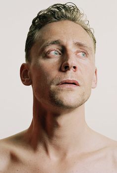 a man with no shirt looking up at something in the air and his eyes open