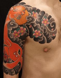 a man's half sleeve with an orange fish and flowers on it