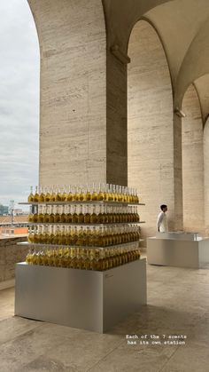 there are many bottles stacked on top of each other in the room with columns and arches