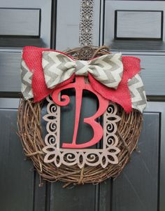 a monogrammed wreath with a bow on the front door is decorated with an initial