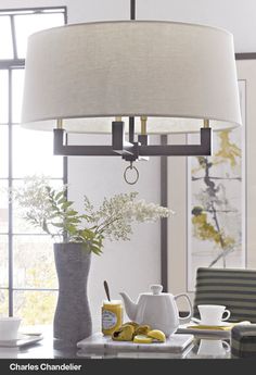 a lamp that is on top of a table with some flowers in the vases