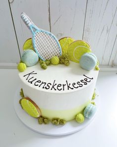 a cake decorated with tennis balls and racquets is on a white table