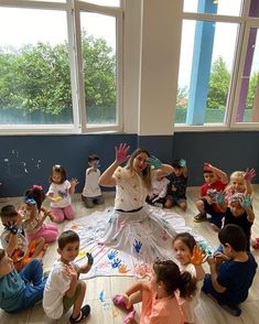 a group of children sitting on the floor with their hands up in front of them