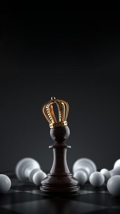 a golden crown sitting on top of a wooden chess piece surrounded by white balls in the dark