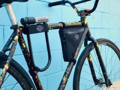 a close up of a bike parked against a blue wall with paint splattered on it