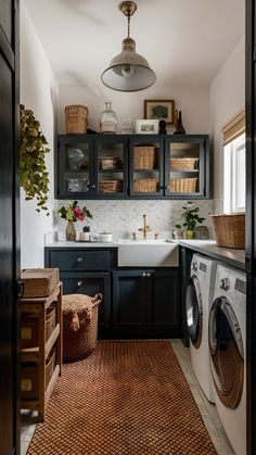 a washer and dryer in a small room with dark wood cabinets, white counter tops, and brown rug