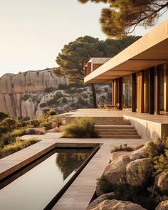 an outdoor swimming pool with steps leading to it and mountains in the background at sunset