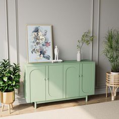 a green cabinet sitting in the corner of a room next to two potted plants