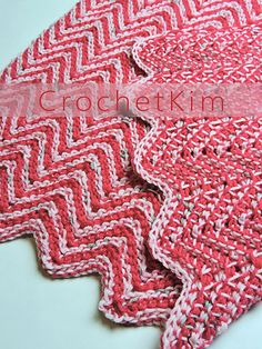 two red and white crocheted rugs sitting next to each other