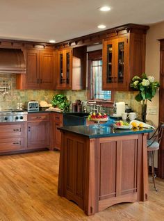 a large kitchen with wooden cabinets and black counter tops, along with an island in the middle