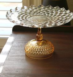 a glass cake plate sitting on top of a wooden table