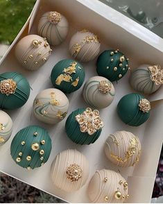 an open box filled with chocolates covered in gold and green frosted icing