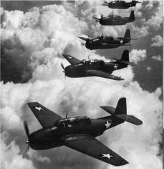 four airplanes are flying in formation above the clouds, with one on top of the other