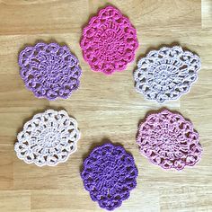 six crocheted doily on a wooden surface