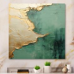 an abstract painting in gold and green on a white wall above a fireplace mantel