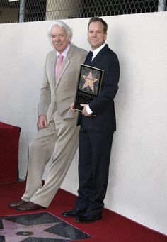 two men standing next to each other in front of a star