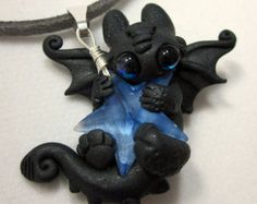 a black and blue necklace with an animal on it