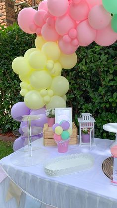 a table topped with lots of balloons and cake