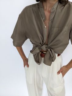 Beautiful latte toned silk top - this blouse has a collarless neckline and iridescent matching buttons down the front & a single breast pocket. Tag reads Personal Choice Faint discolorations at the sleeves and at front with very subtle discolorations under arms. Classic Neutral Blouse For Summer, Elegant Rolled Sleeves Spring Blouse, Elegant Spring Blouse With Rolled Sleeves, Chic Daywear Blouse With Pockets, Elegant Summer Shirt With Pockets, Chic Blouse With Pockets For Daywear, Casual Silk Blouse With Buttons, Elegant Tops With Rolled Sleeves, Elegant Neutral Tops For Daywear