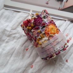 a bunch of flowers on top of a white sheet next to a framed photo and a book