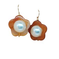 These stunning earrings feature a unique design with a large, lustrous faux pearl nestled in the center of a carved carnelian flower. The warm, golden hues of the carnelian complement the pearl's cool, iridescent glow, creating a truly eye-catching piece. The delicate wire wrapping adds a touch of elegance, while the slightly heavy design ensures comfortable wear. These earrings are perfect for adding a touch of sophistication to any outfit. Moody Pearl Flow Dangles Details: carnelian flower ora Mens Earrings Hoop, Men Earrings, Stunning Earrings, Guinea Bissau, Wire Wrapping, Faux Pearl, Unique Design, Dangle Earrings, Hoop Earrings