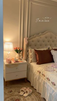 a bedroom with a white bed and pink flowers on the nightstands next to it