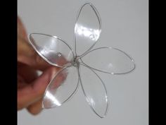 a hand holding a piece of glass with a flower shaped object in it's center