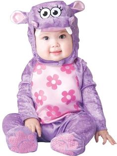 a baby in a purple monster costume sitting on the ground with its eyes wide open