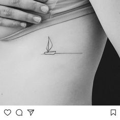 a woman's stomach with a small sailboat tattoo on her left side ribcage