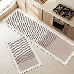 two kitchen mats sitting on top of a counter next to an oven and stovetop