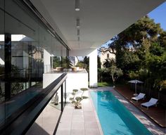 an empty swimming pool in the middle of a house with glass walls and sliding doors