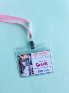 an id badge is attached to a lanyard on a light blue background with pink ribbon