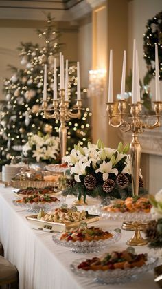 a long table covered in lots of food next to a christmas tree