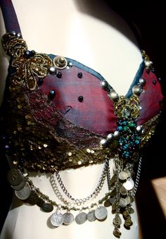 a close up of a mannequin wearing a bra with chains and coins on it