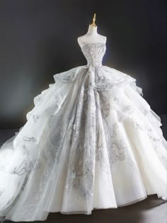 a white wedding dress on display in front of a black background